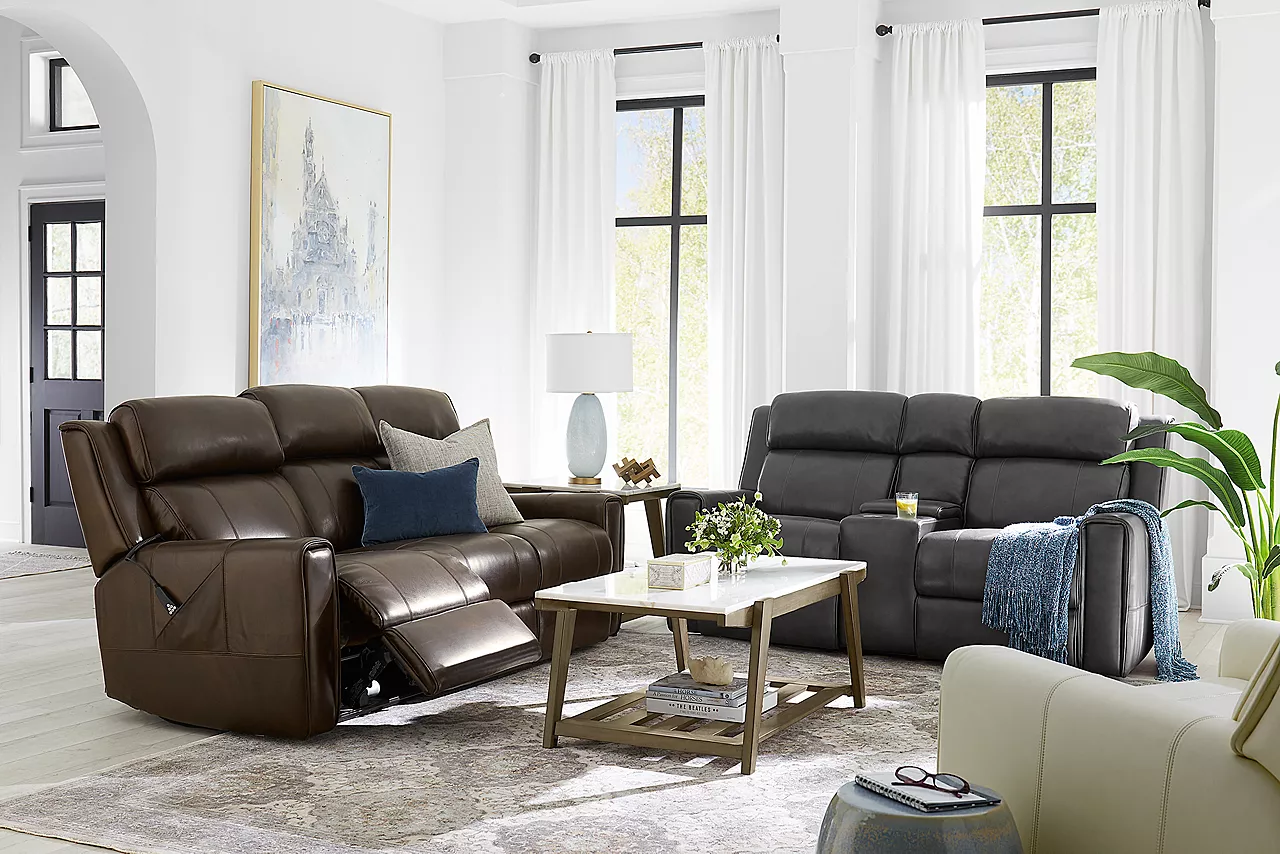 Gibson sofa in Chocolate with one side reclined, loveseat in Dark Grey and a recliner in Cream in a room scene.