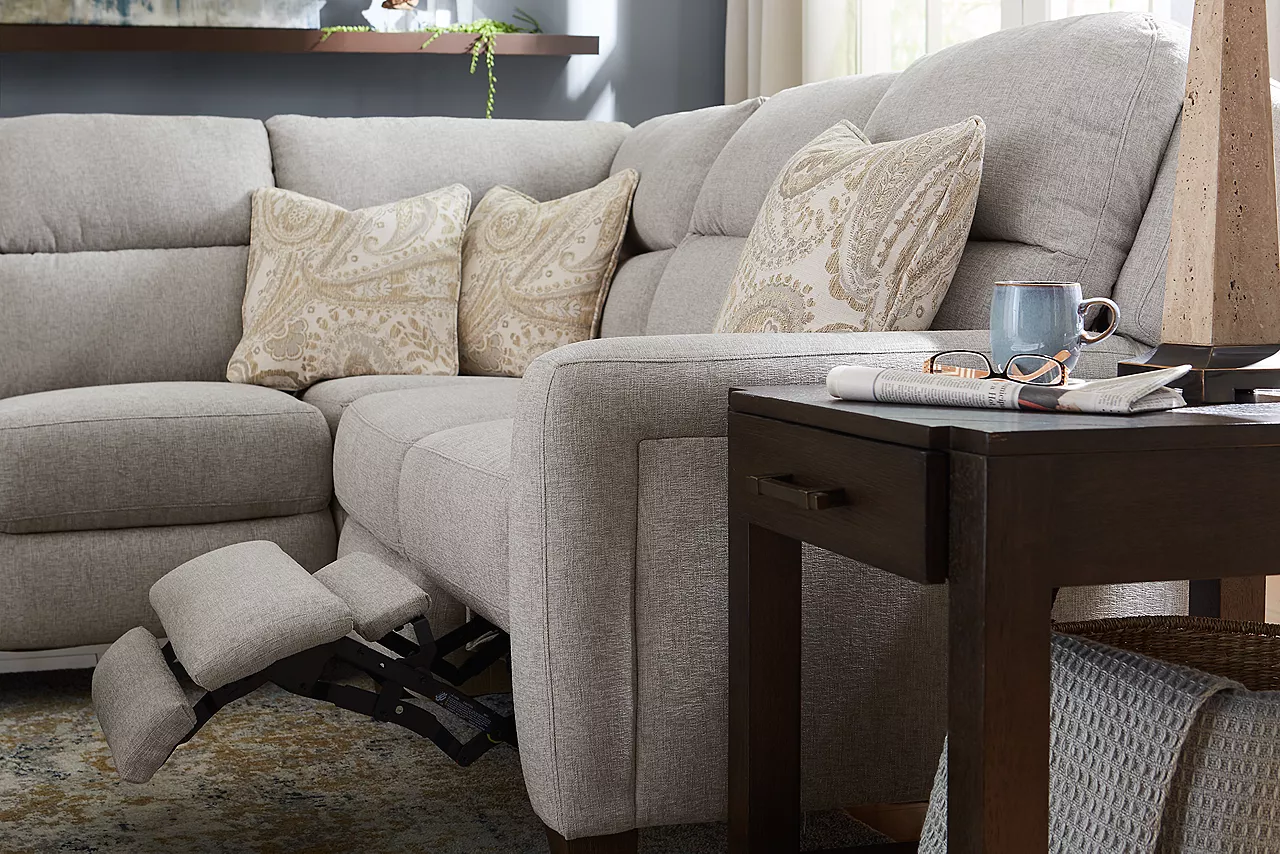 The fabric Ava sectional with one side reclined and a Brody end table in room scene.