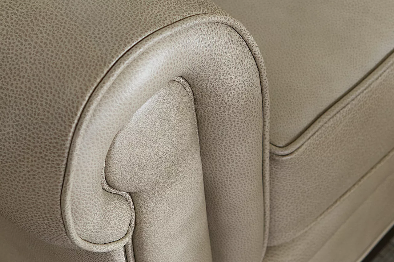 A closeup view of a Hartford Sofa in Pebble showing the texture of the leather and the detail of the arm rest in a room scene.