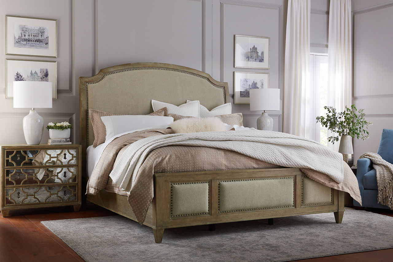 Westcliffe upholstered bed shown with mirror nightstand in room scene.