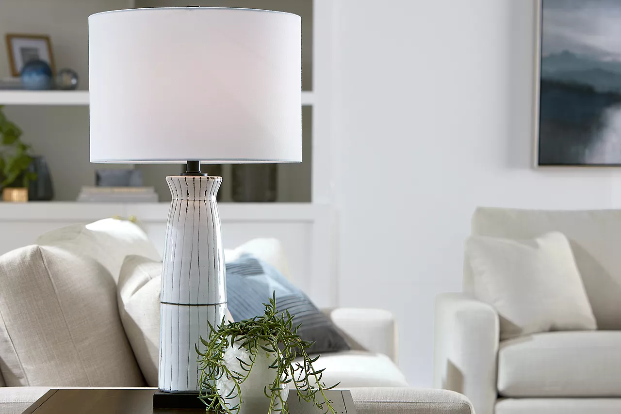Rhinebeck Table Lamp, Destinations 3-Seat Sofa, and Swivel Chair in Convert Ivory in a room scene.