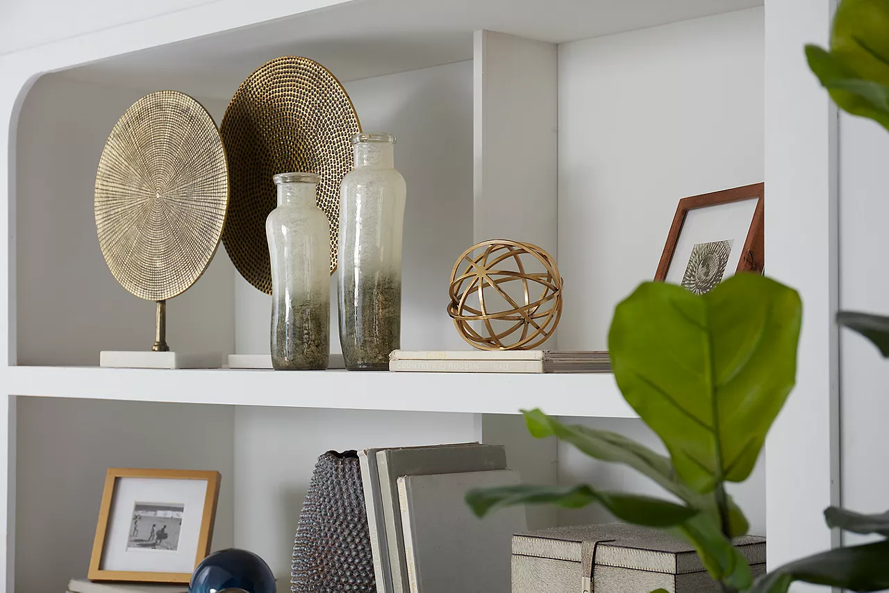 Bookshelf with various items on it in a room scene.