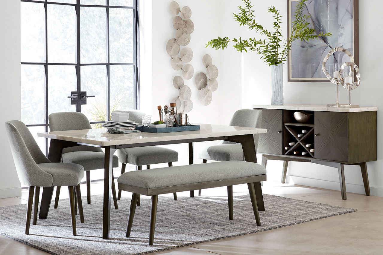 Avalon Dining Table in White Marble and Avalon Upholstered Dining Chairs, Upholstered Bench and Server in Grey in a room scene.