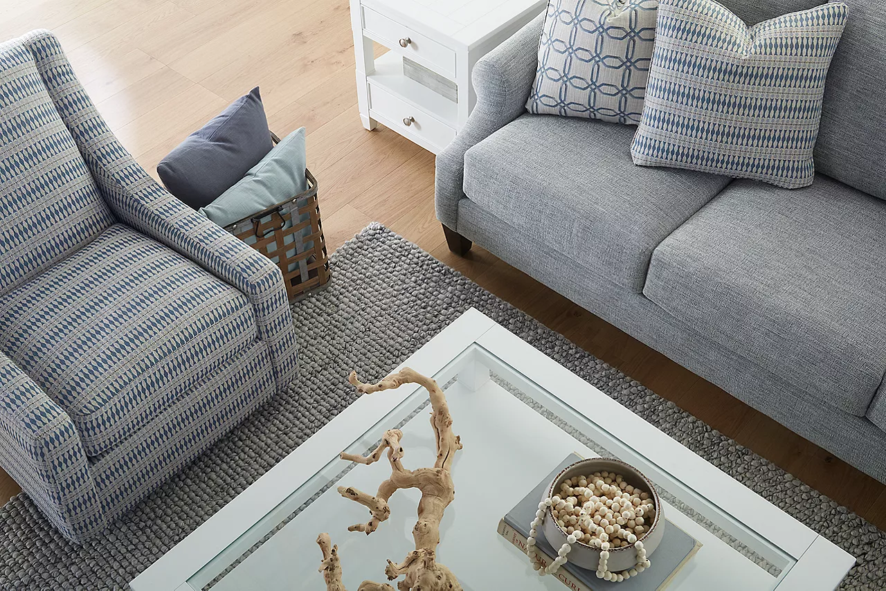 Gigi Sofa in Hornet Silverpine and Gigi Swivel Chair in Fine China Wedgewood Blue and an Avondale coffee and end table in a coastal room scene.