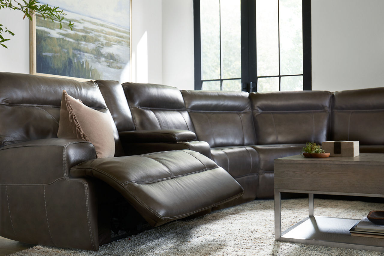 Regis Sectional in Pewter with one side showing reclined and a Sidney coffee table in a room scene.