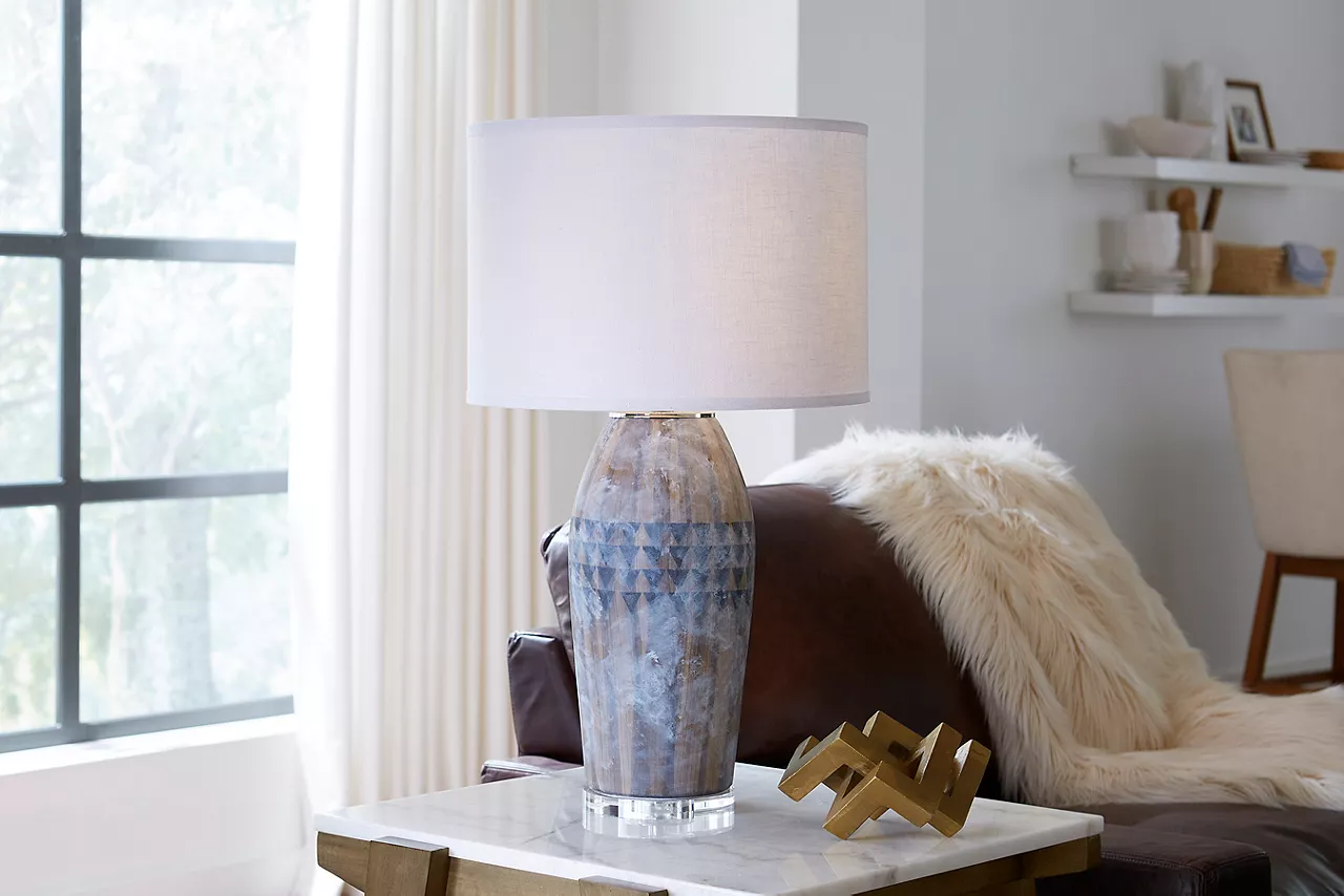 Image of a lamp and small sculpture on a marble end table