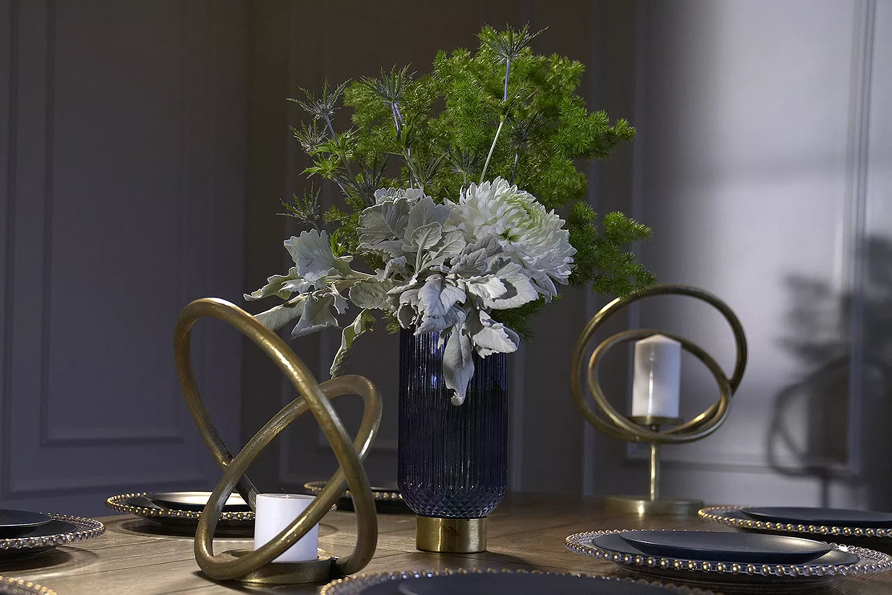 Vase with flowers next to two candle holders