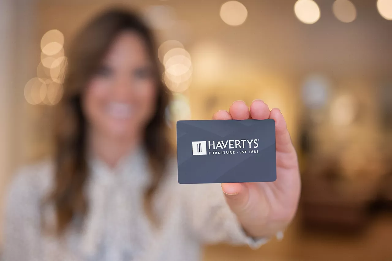 Woman holding up Havertys credit card