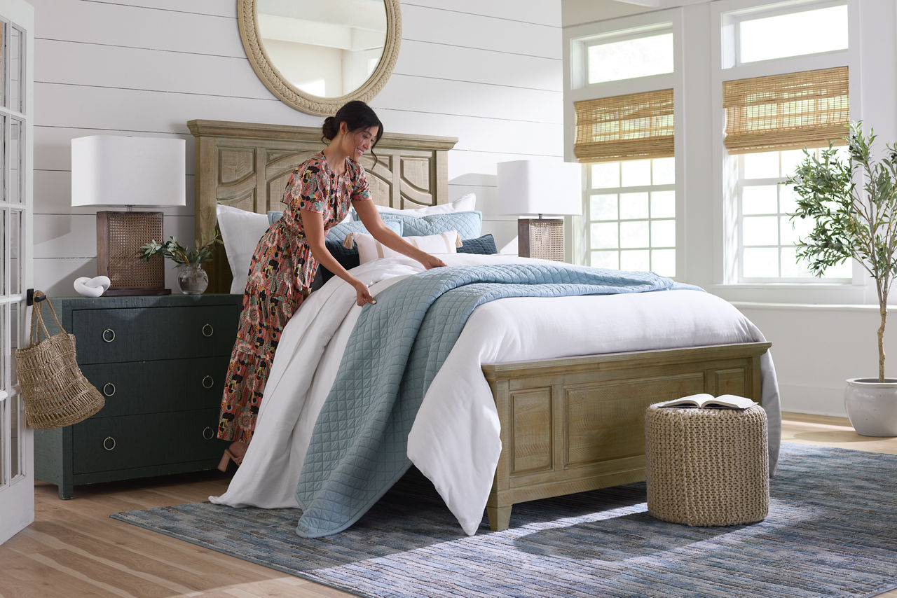 A Woman Model Making the bed of a Serta Arctic Mattress in a room scene.